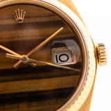 Closeup Photo of a Rolex Datejust 1601 Tiger Eye from 1974. 36mm with 18K yellow gold case, Tiger Eye stone dial, Automatic movement and Leather strap.